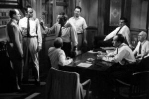 A group of men standing around a table.