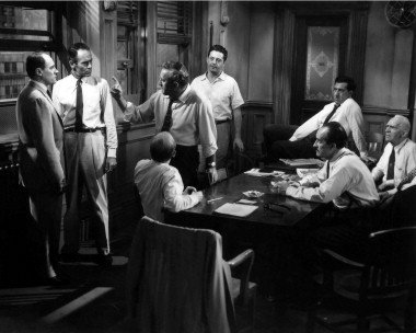 A group of men standing around a table.