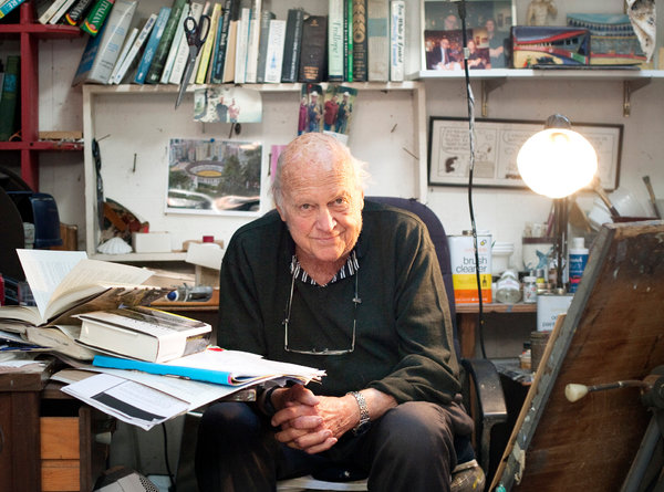 A man sitting in a chair with papers on the floor.