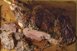 A piece of meat on top of a wooden cutting board.