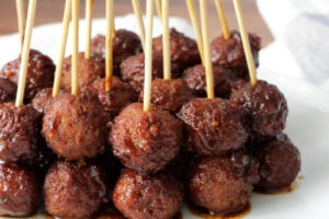 A plate of meatballs with sauce on top.