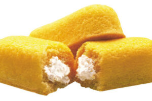 A close up of two twinkies with one bite taken out