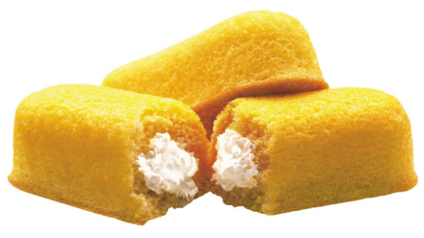 A close up of two twinkies with one bite taken out