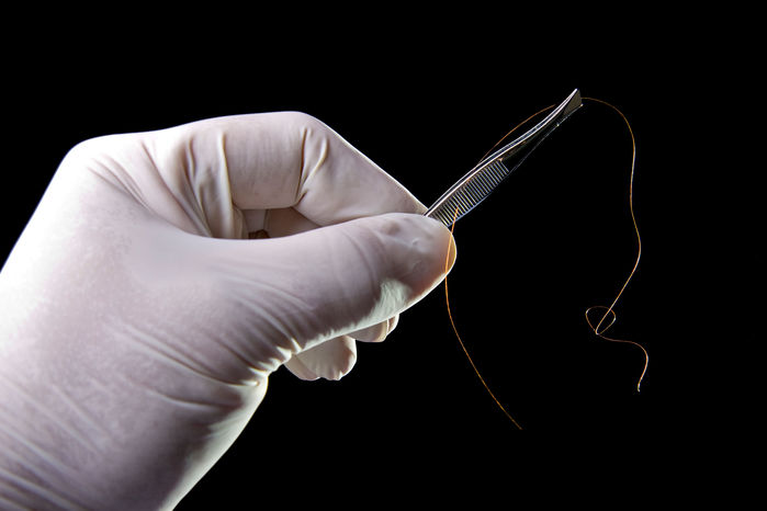 A person holding a needle in their hand.