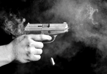 A person holding a gun with smoke coming out of it.